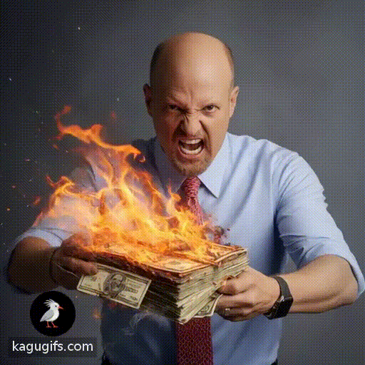 Bald man with goatee in light blue shirt and red tie igniting a stack of money on fire with intense expression.