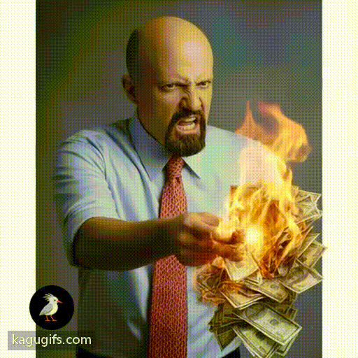 Bald man with goatee in light blue shirt and red tie igniting a stack of money on fire with intense expression.