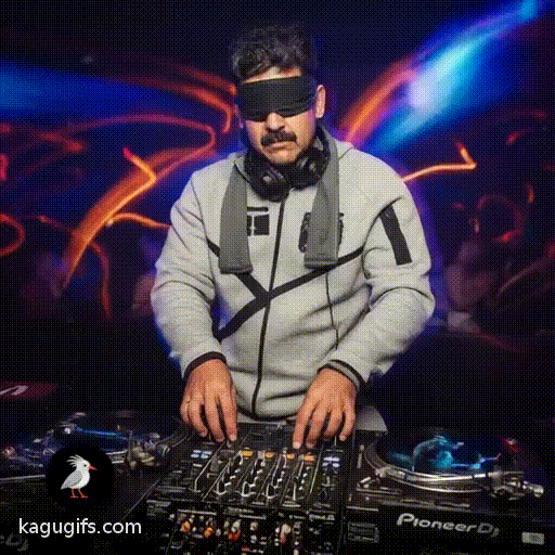 Man with dark mustache wearing grey tracksuit and blindfold, standing confidently at DJ booth with headphones around neck, hands positioned on turntables mixing tracks, bobbing head rhythmically to the beat in energetic club atmosphere.
