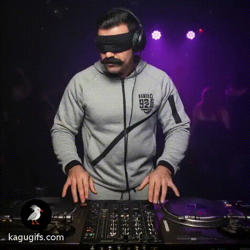 Man with dark mustache wearing grey tracksuit and blindfold, standing confidently at DJ booth with headphones around neck, hands positioned on turntables mixing tracks, bobbing head rhythmically to the beat in energetic club atmosphere.