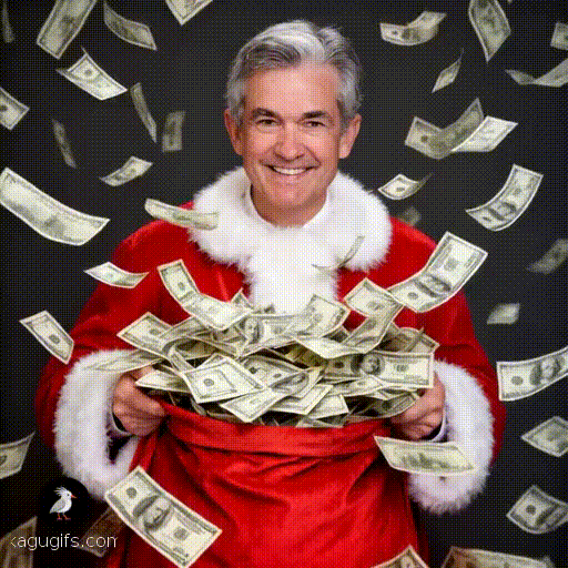 Jerome Powell in a festive red Santa costume with white fur trim, smiling warmly, holding a large sack with dollar bills flowing out and fluttering downward through the air around him.