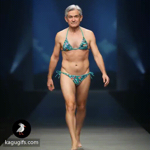 Jerome Powell with salt-and-pepper hair, confident expression, and professional bearing, striding purposefully across a stage wearing a bikini, arms swinging naturally as he walks forward with commanding presence.