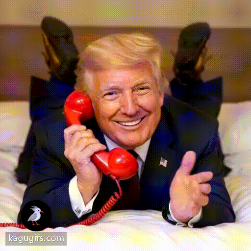 Donald Trump with distinctive golden-blonde hair and business suit laying down face on a bed facing towards the camera with his legs in the air behind him talking happily on a red telephone, cheerful expression, animated gesturing.